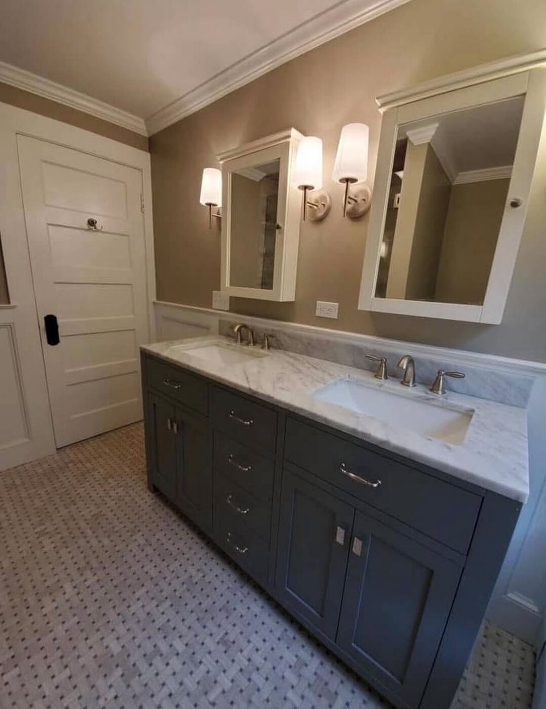 Bathroom remodel with a double marble vanity, wall sconces and two medicine cabinets