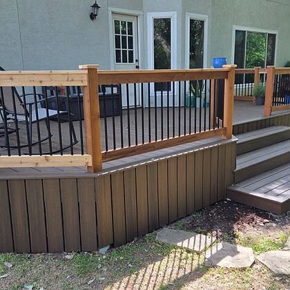Cedar deck railing with black metal balusters and a stained skirt board